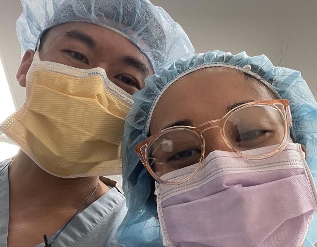 Two doctors take a selfie in protective garb