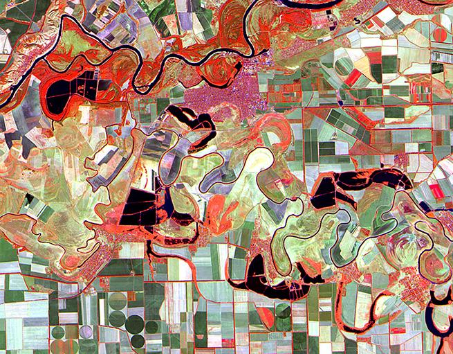 Satellite image, with both visible and nonvisible light wavelengths, showing the path of a river through and surrounding farm fields in the Rostov region of Russia.
