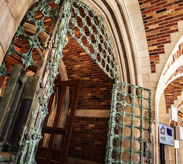 A green gate and brick archways in the Humanities Quadrangle