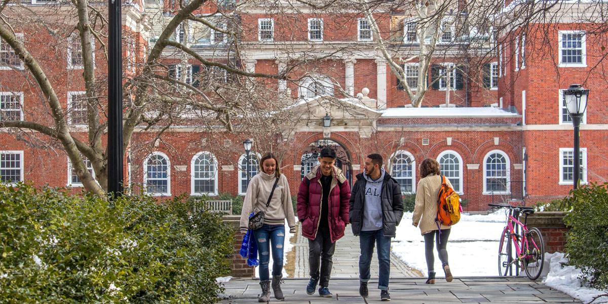 a group of students walking on campus in the snow