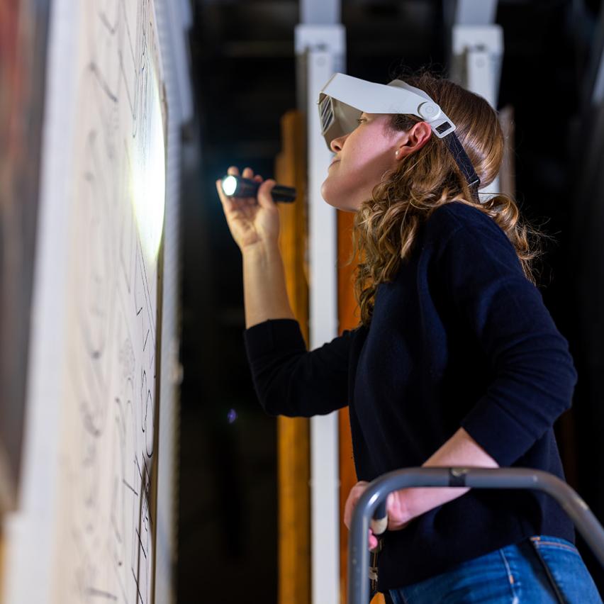 A Yale conservator examines a painting