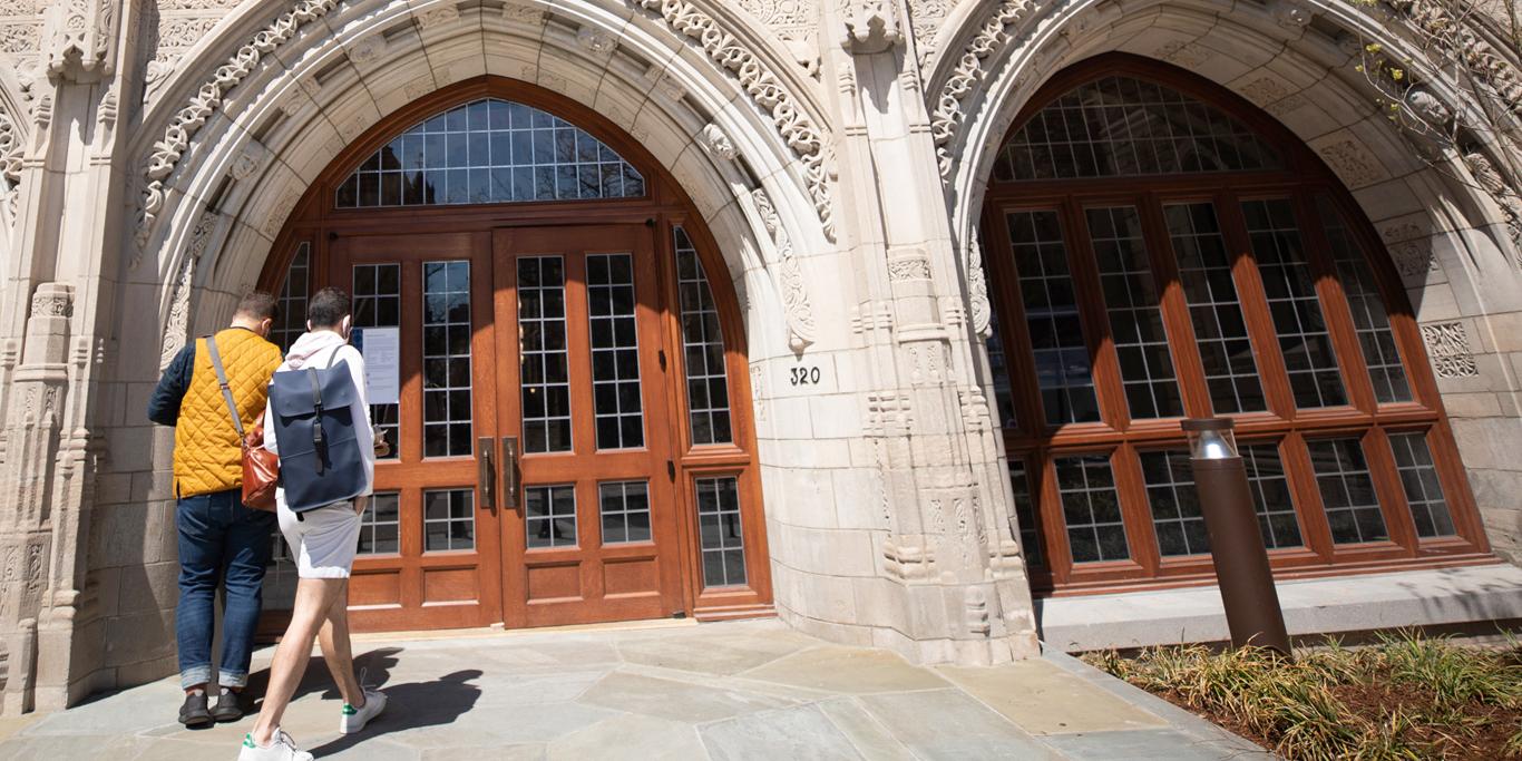 Two students walking toward the doors of Humanities Quadrangle