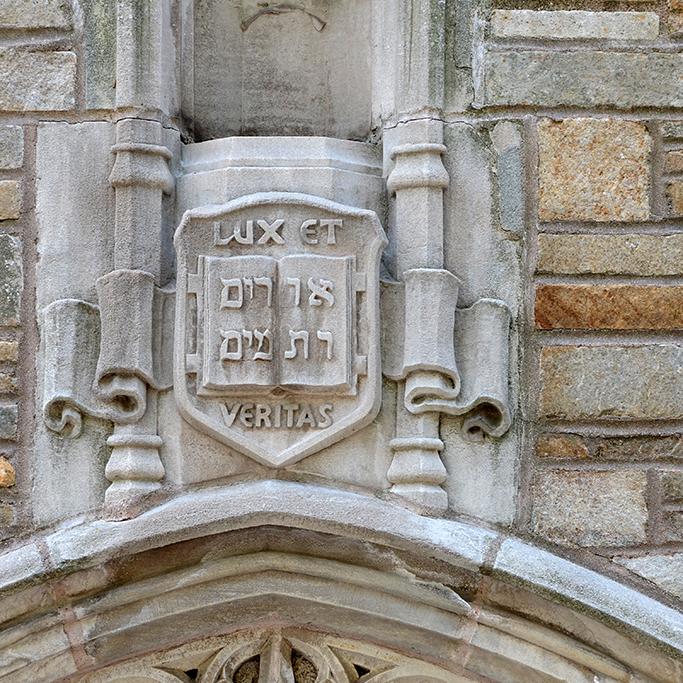 Detail of "Lux et Veritas" carved into the stone wall of a building