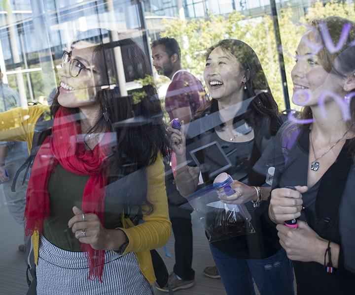 Students paint on the glass wall of the Yale School of Management building