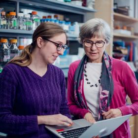 Dean Lynn Cooley working with a graduate student in a laboratory