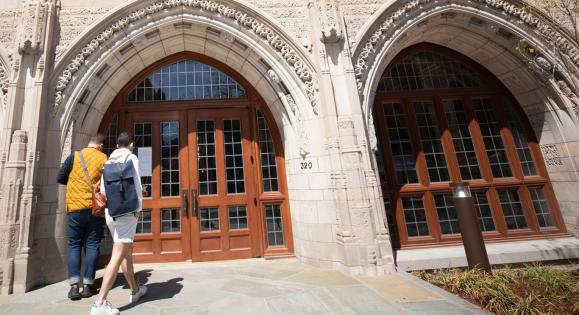 Two students walking toward the doors of Humanities Quadrangle