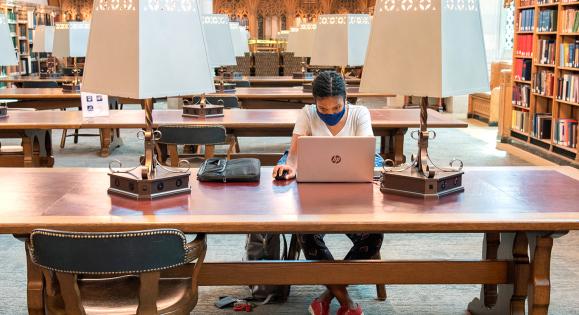 Student working on a laptop in a library
