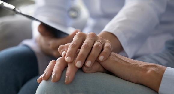 Closeup of a doctor holding a patient's hand