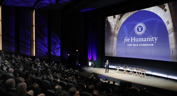 For Humanity Illuminate event with a speaker on stage speaking to a large audience