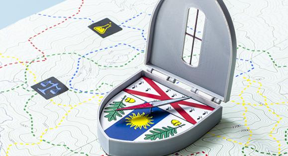 Compass with Yale School of the Environment crest on it sitting on a map