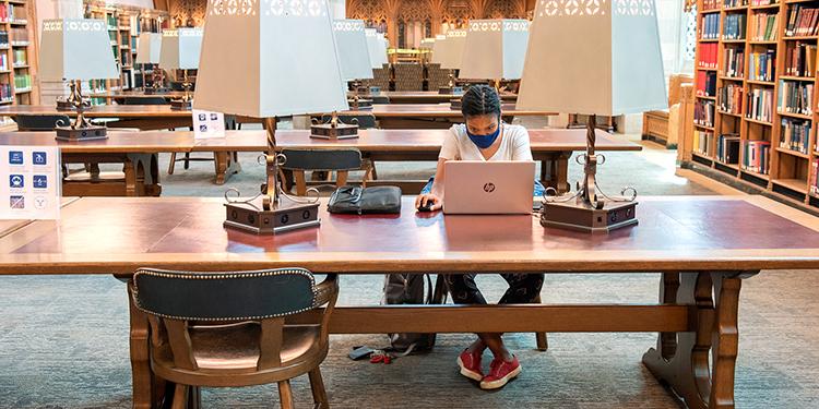 Student working on a laptop in a library