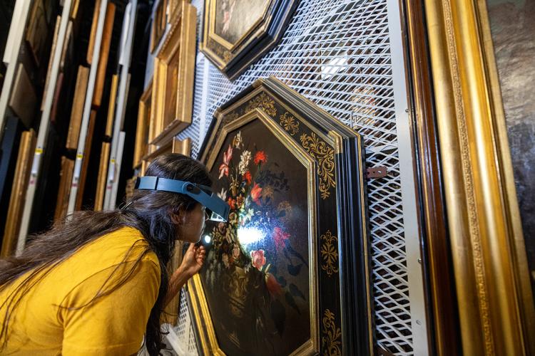 A Yale post-graduate conservation trainee examines a painting