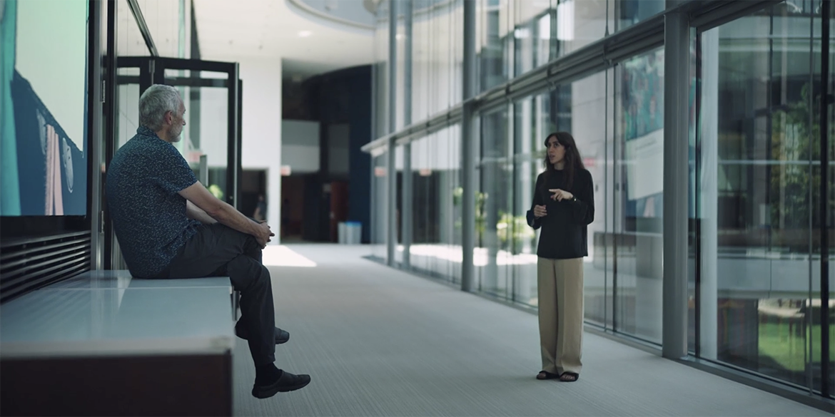 Two people in conversation in a windowed room